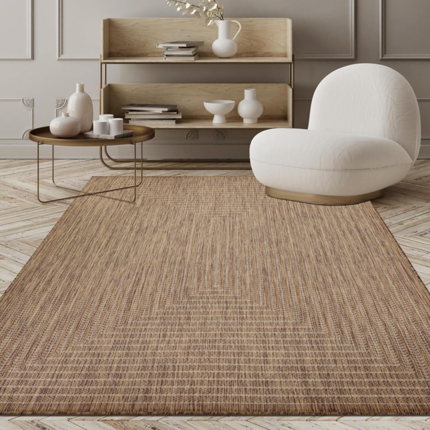 Low-angle living room view of a warm tan woven area rug under a round table and white lounge chair.