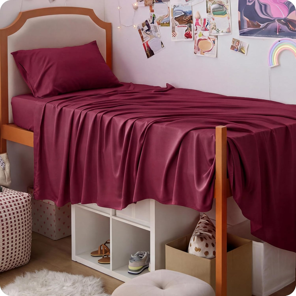 Loft-style single bed dressed in deep burgundy silky sheets with storage cubbies underneath