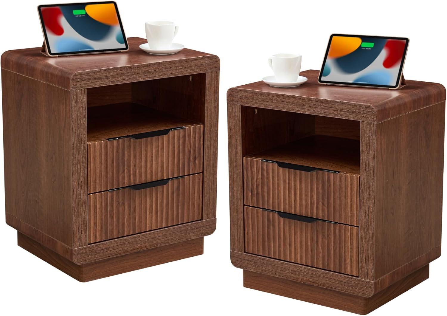 Two compact walnut nightstands with an open shelf and two ribbed drawers, tablets and cups on top.