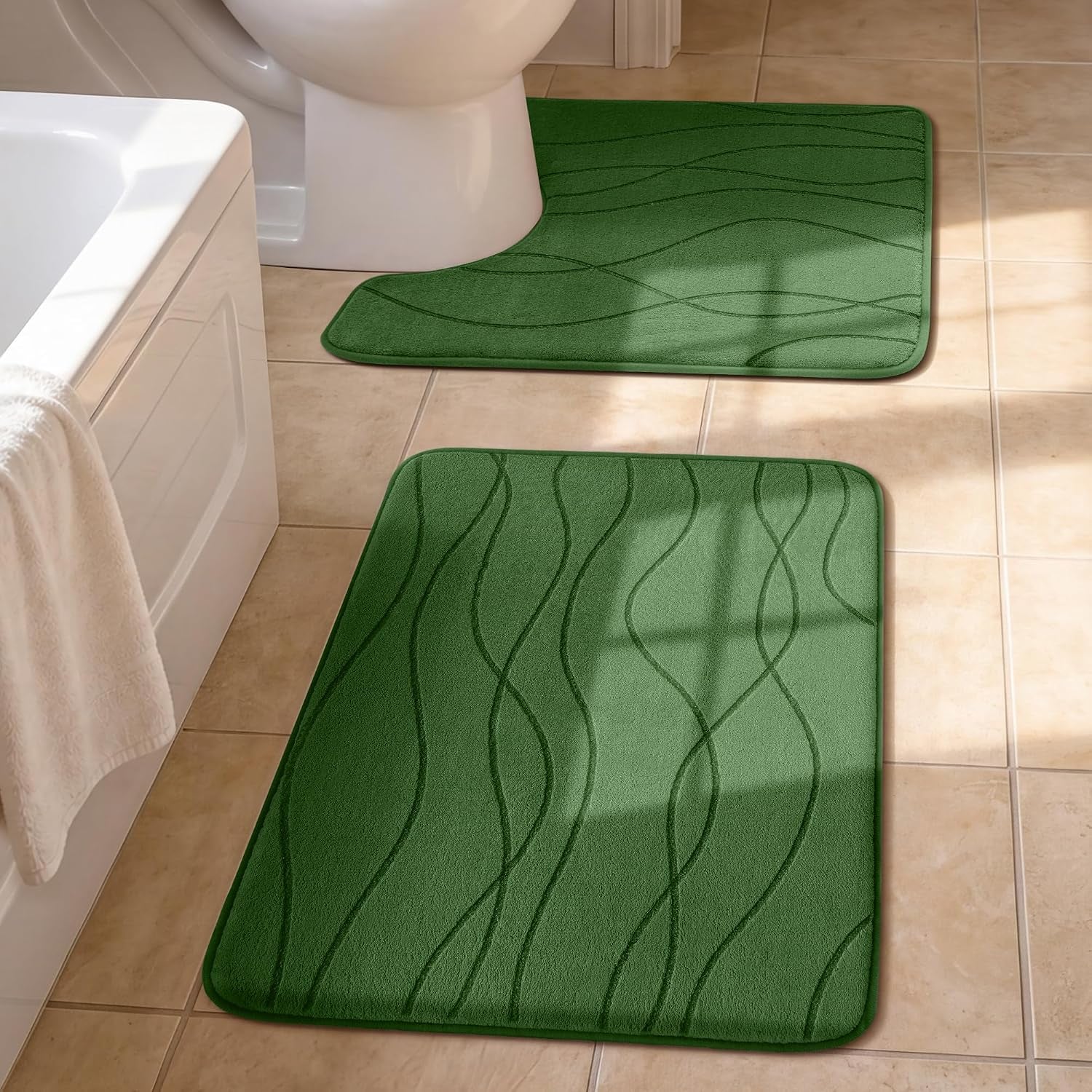 Green U-shaped toilet rug and matching rectangular bath rug on tan tile beside a tub.