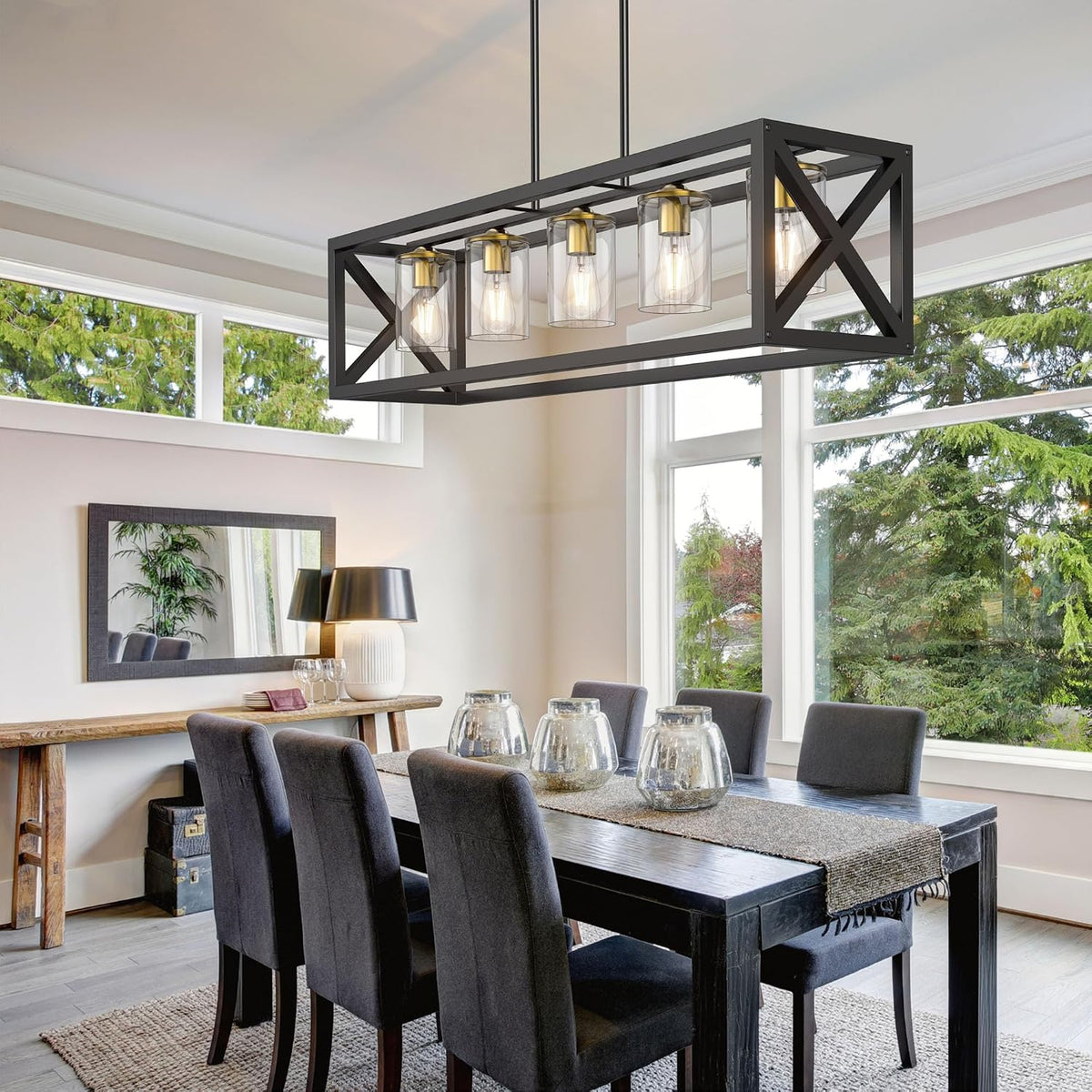 Rectangular metal pendant light with clear cylindrical shades shown over a long dining table in a bright room