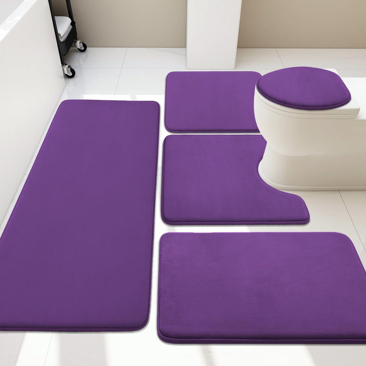 Overhead bathroom view showing a purple five-piece bath rug set arranged around a toilet.