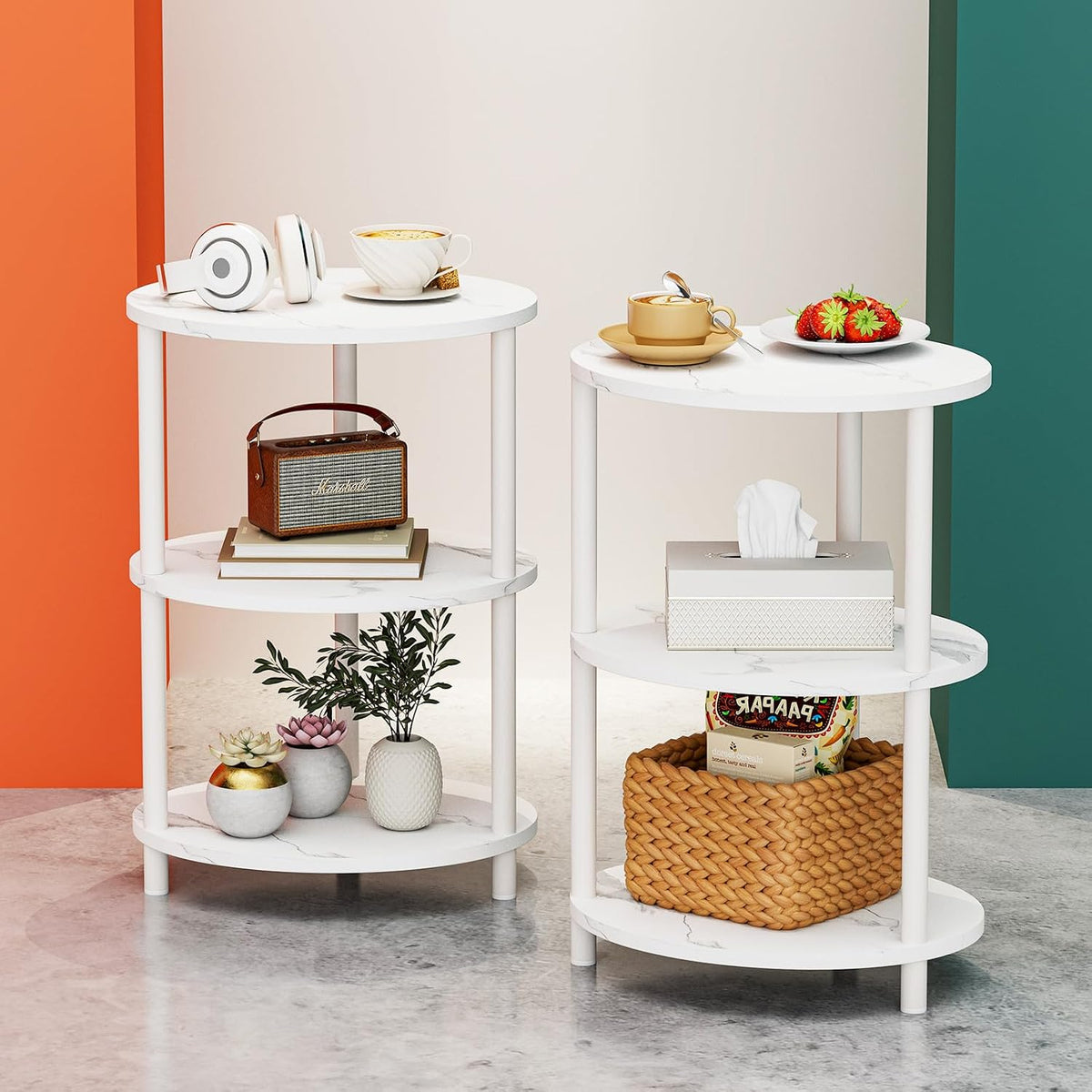Two small white round three-tier end tables staged with cups, a radio and plants in a studio setting.