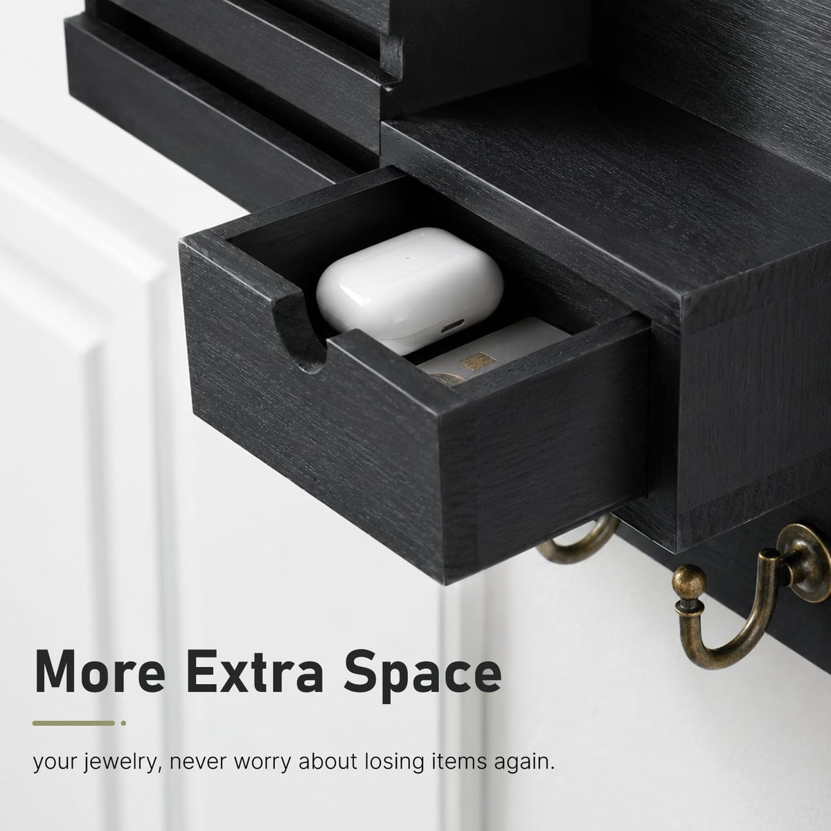 Tight close-up of the black drawer pulled out showing earbuds case and small items inside.
