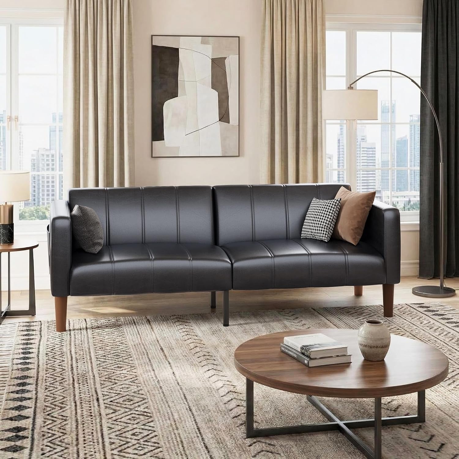Black faux leather futon in a bright living room scene with wooden legs and narrow arms