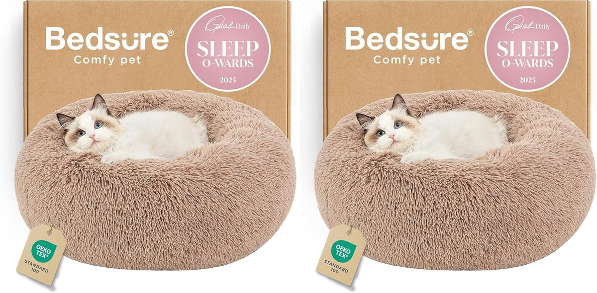 Two beige round faux-fur donut beds side by side each with a cat curled inside