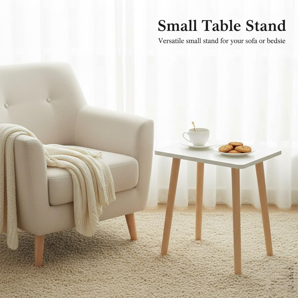 Small white side table with light wood legs beside a cream armchair and cup of tea