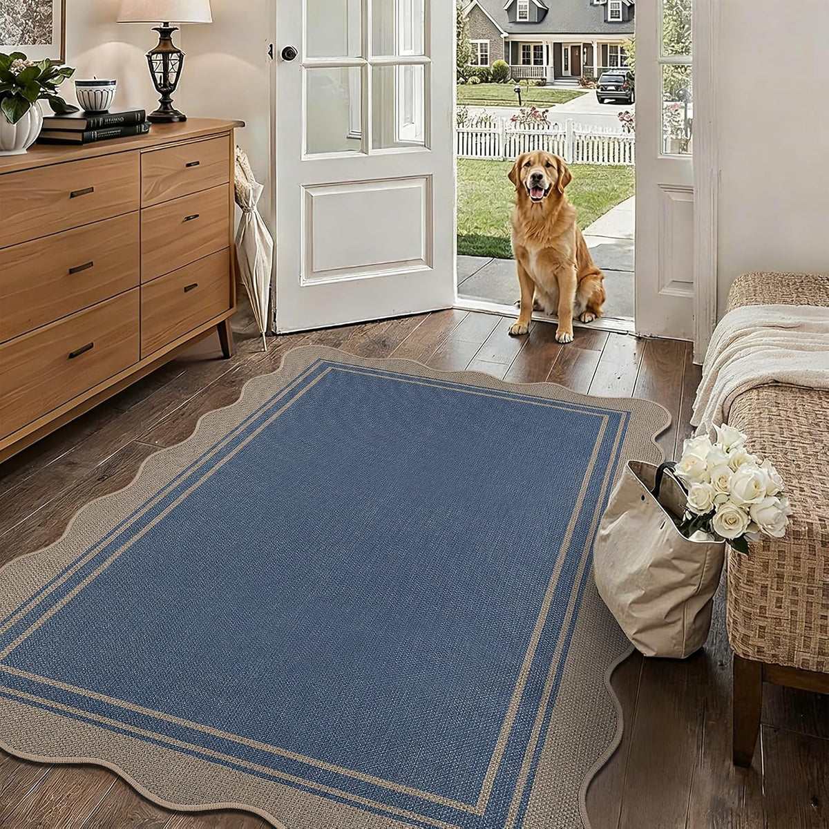 Entryway with a scalloped blue rug on wood floor and a golden retriever sitting at the open door.