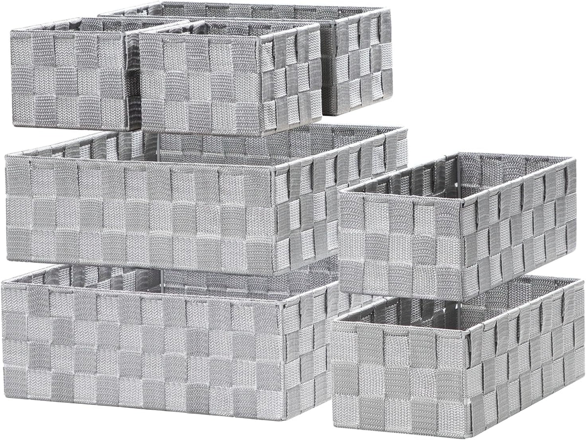Six woven rectangular storage baskets staggered in a stacked arrangement on a white background.