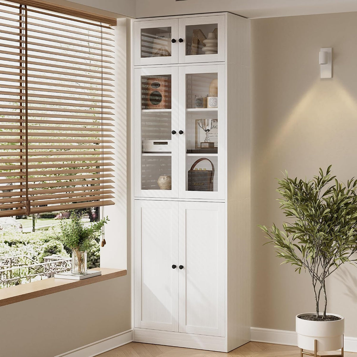 Close view of the white bookcase showing glass-front middle doors with decor items inside.