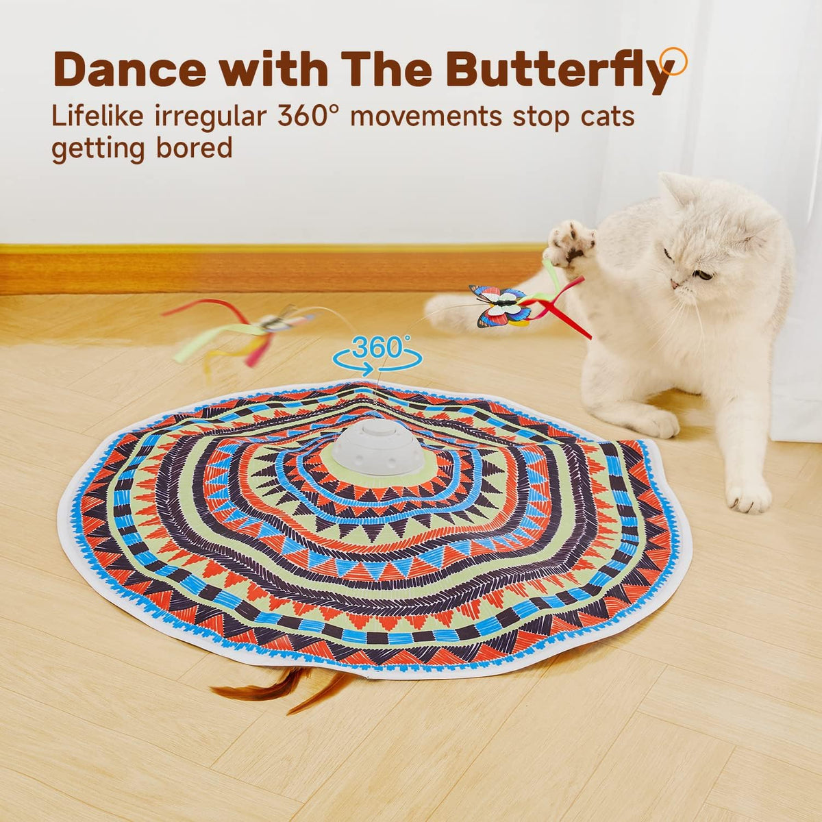 Action shot — white cat reaching out to bat a colorful butterfly toy while the patterned mat's center indicates 360°