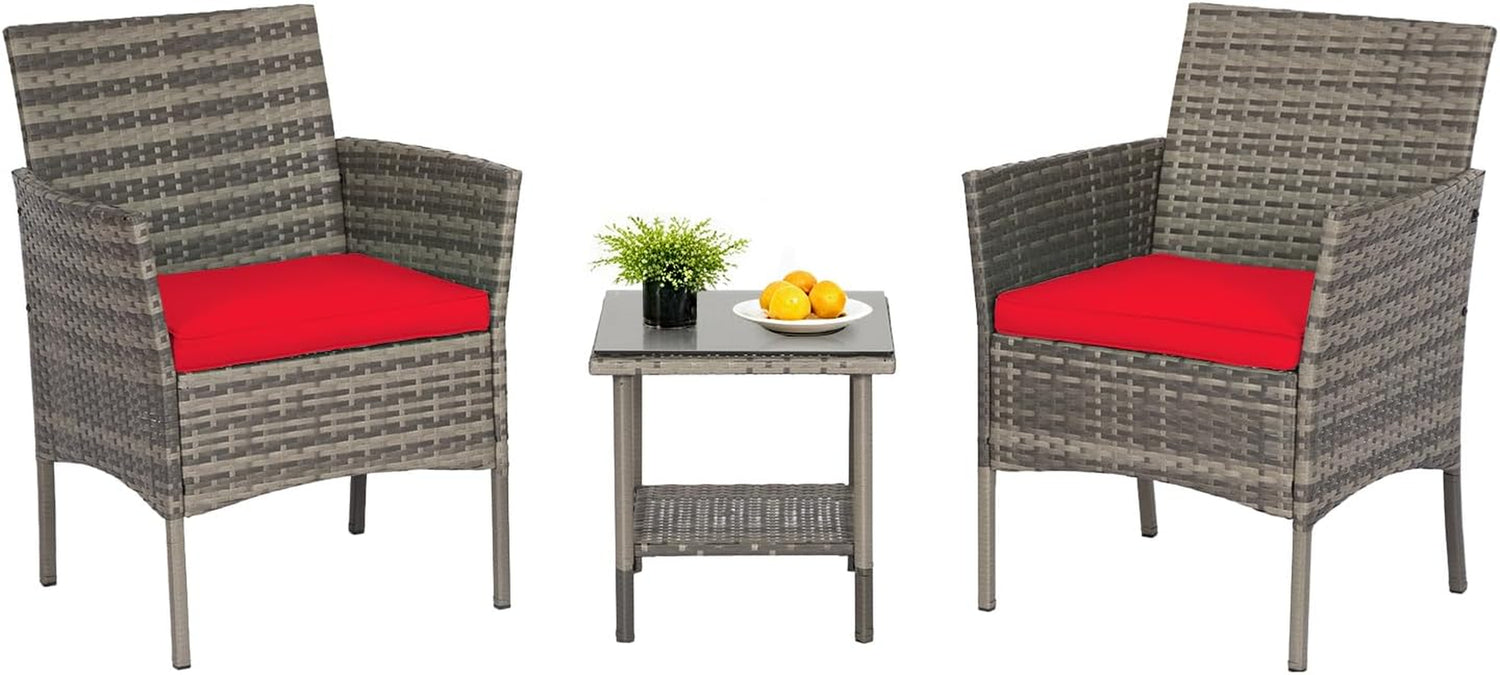 Two gray wicker armchairs and glass-top side table with bright red seat cushions