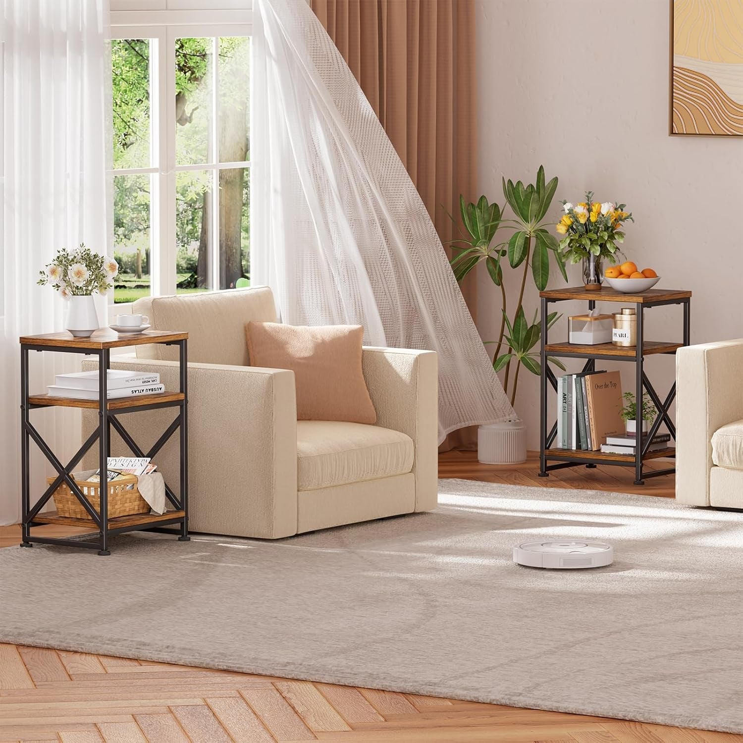Pair of three-tier side tables with X-frame beside armchairs in a bright living room setting.
