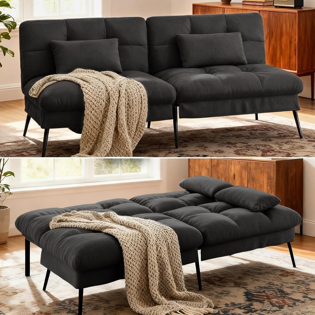 Black futon sofa in living room angled front view with throw blanket and lumbar pillow