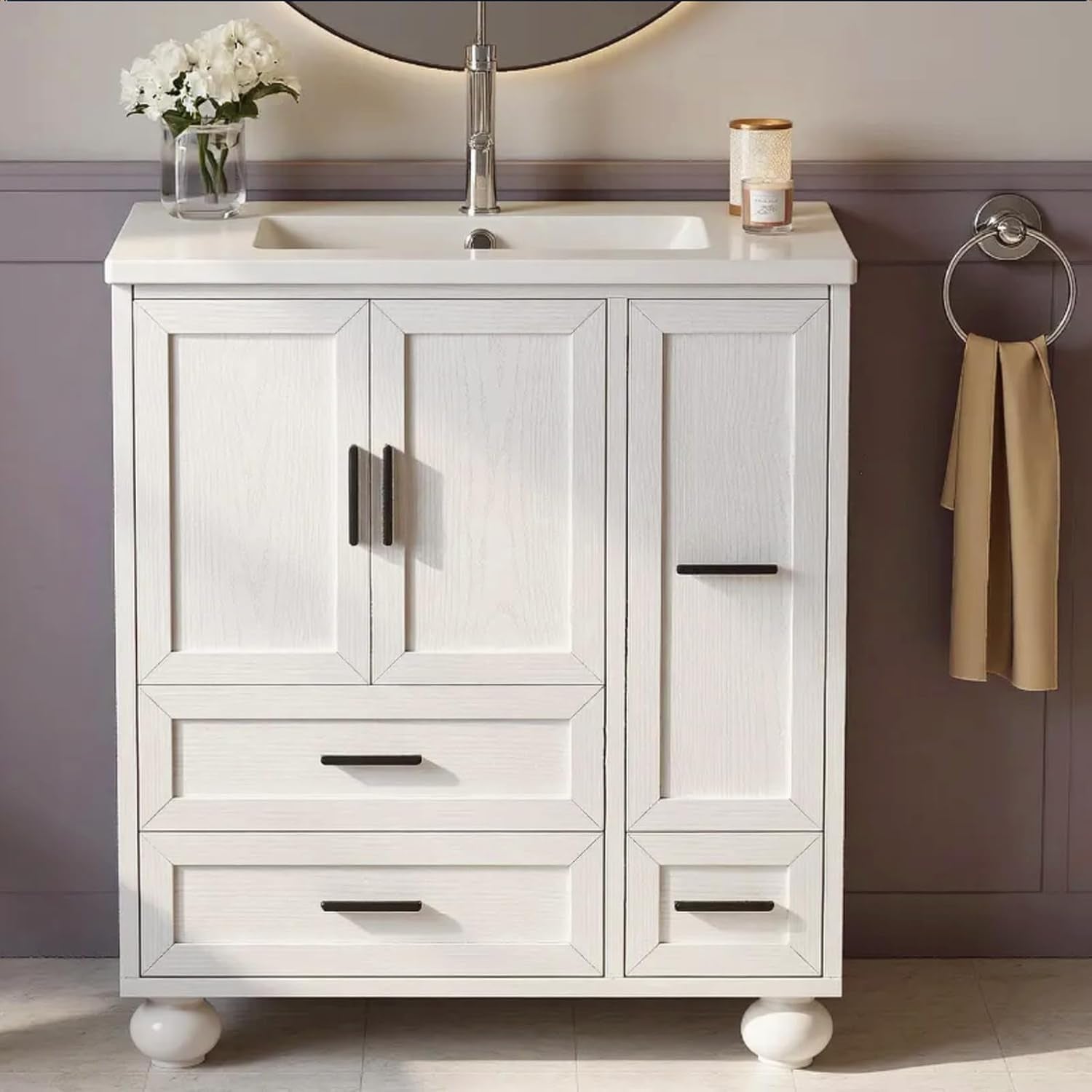 White raised-panel bathroom vanity front view with undermount sink, two doors, drawers and round bun feet