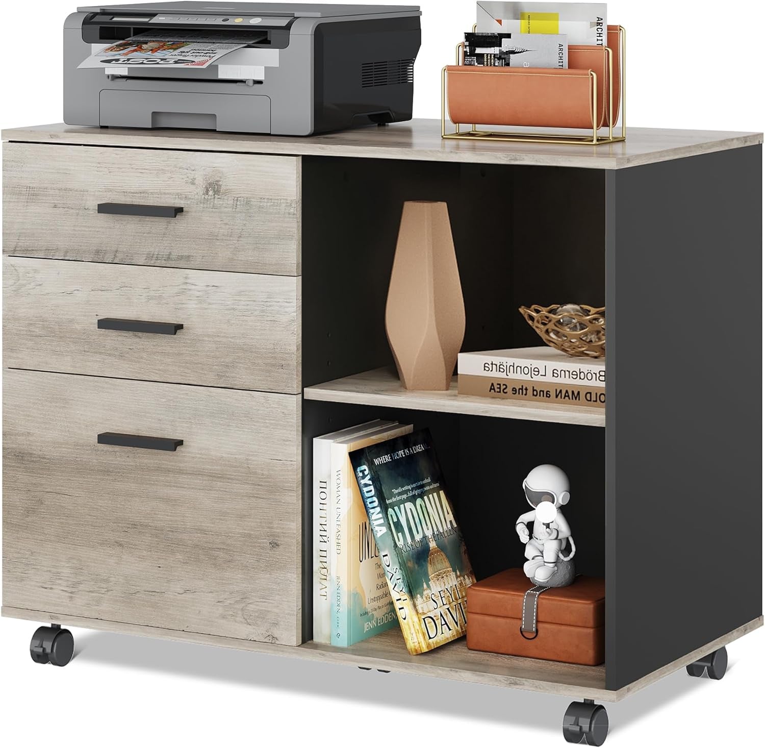 Three-drawer mobile cabinet in light wood finish with open shelving, books and decor, caster wheels visible.