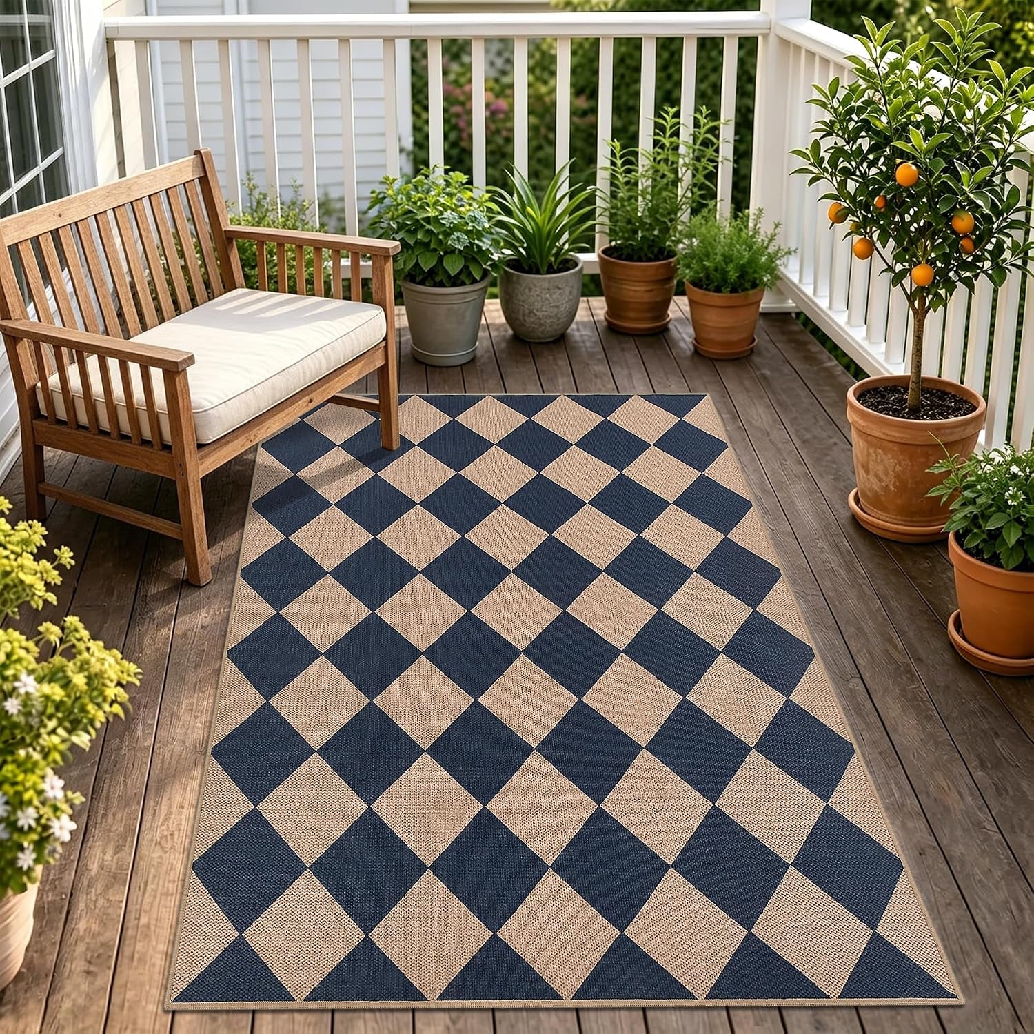 Diamond-check navy and beige rug on a wooden balcony with a bench and potted plants.