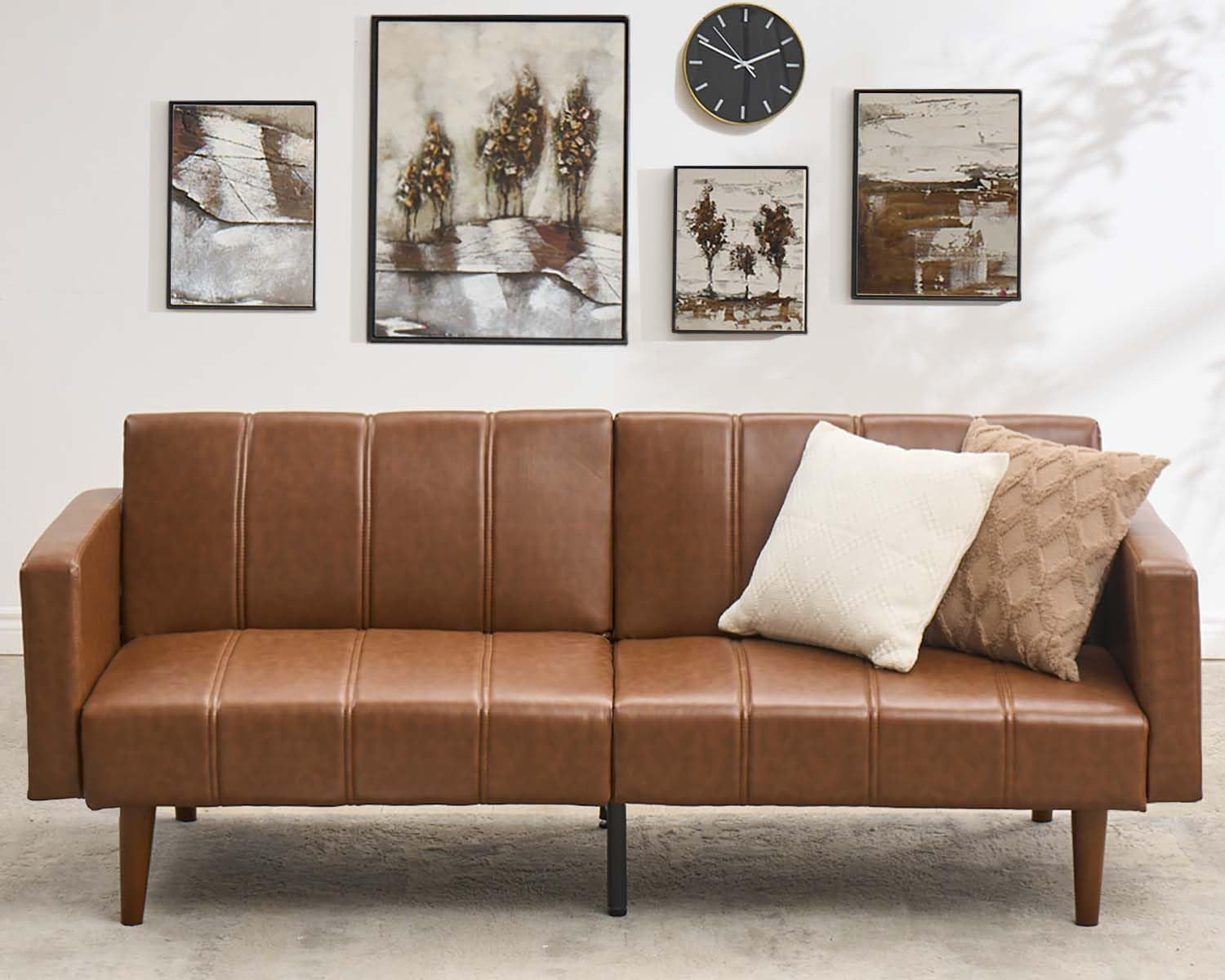 Front view of brown futon sofa showing stitched seat panels and two throw pillows