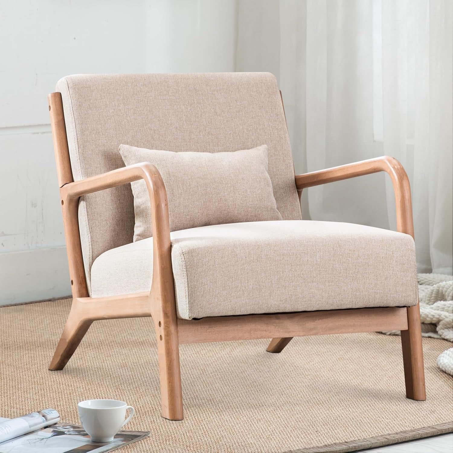 Angled front-right view of a beige upholstered accent chair with natural wood frame and a small lumbar pillow.