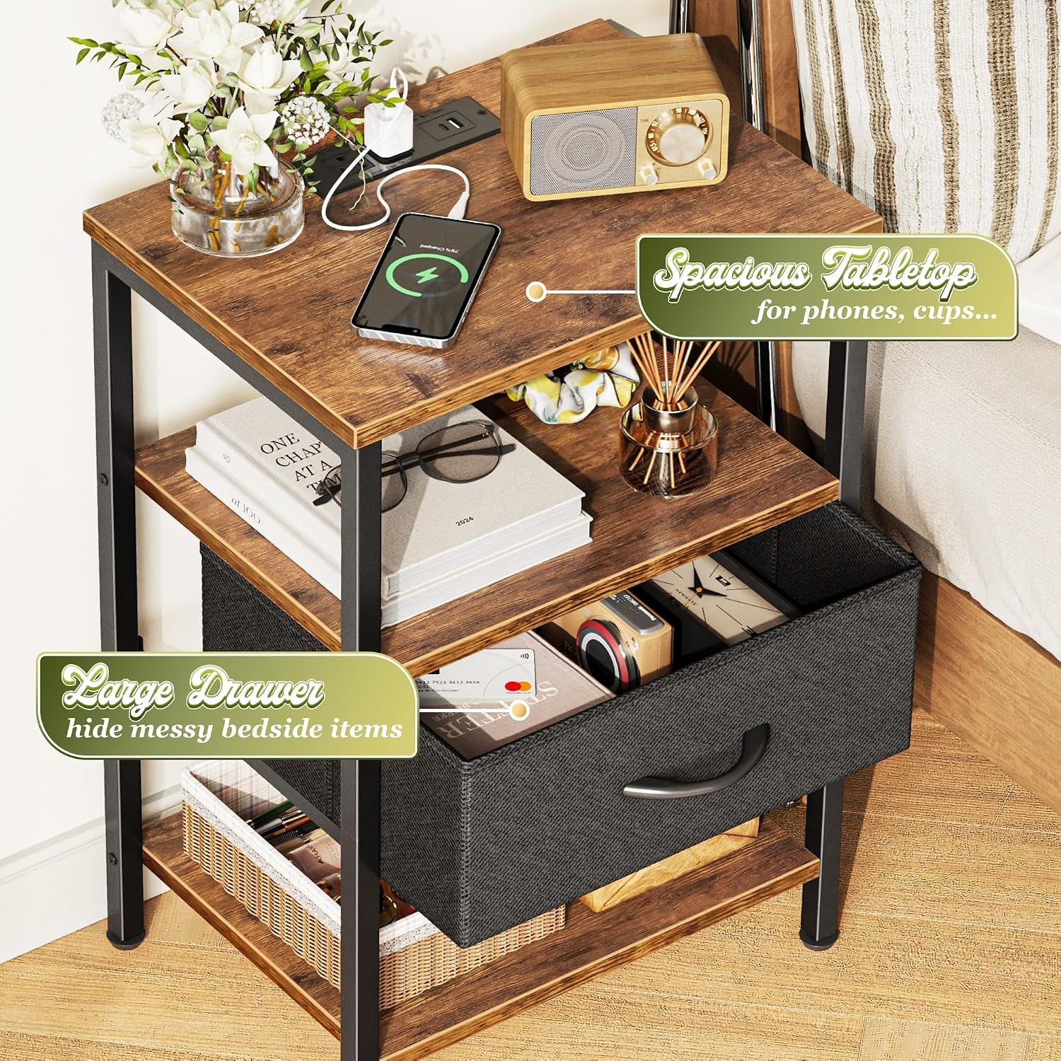Three-tier wood-and-metal nightstand with charging phone on top and an open fabric drawer showing stored items.