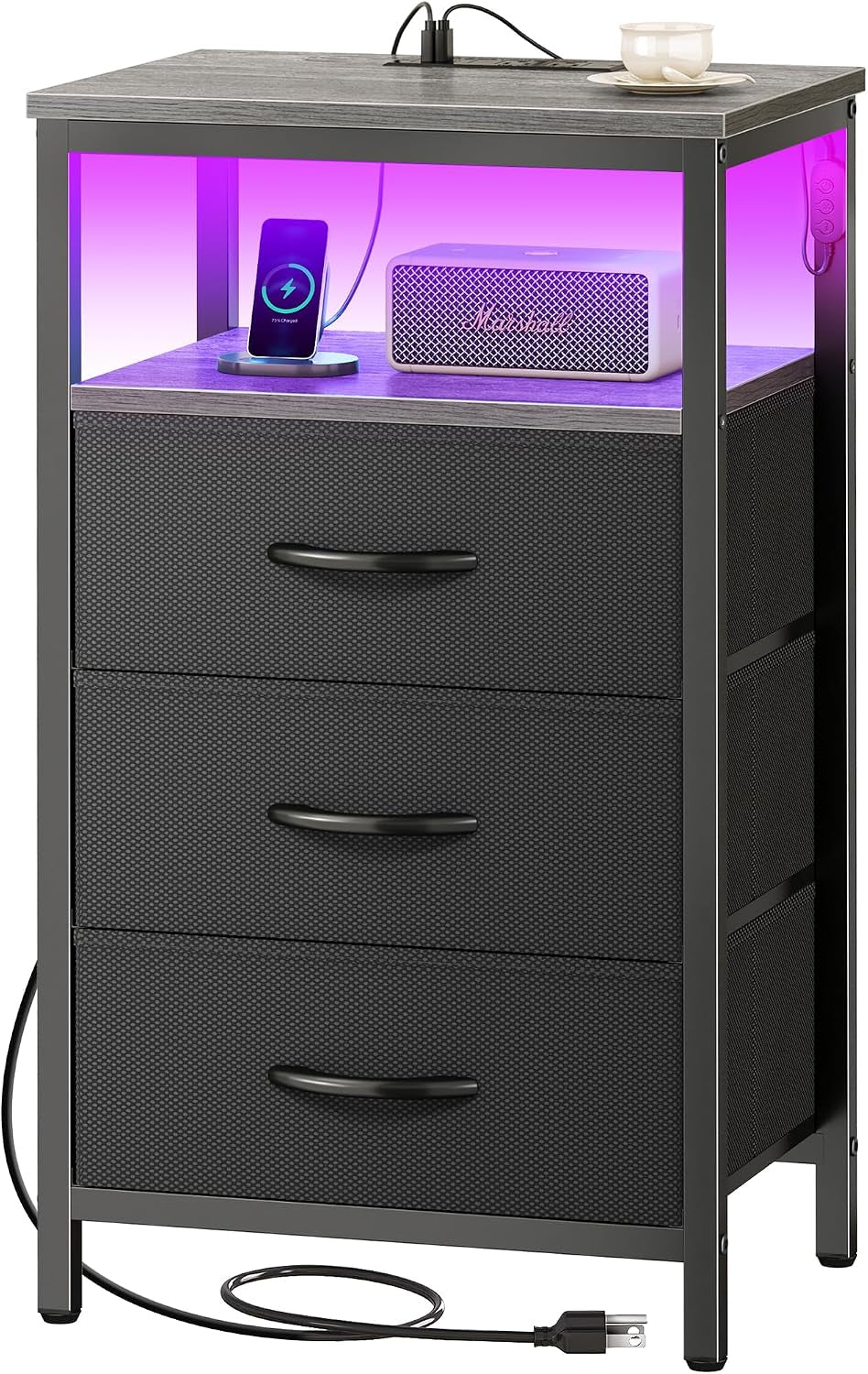 Black bedside cabinet with three fabric drawers, illuminated top shelf showing phone and speaker.