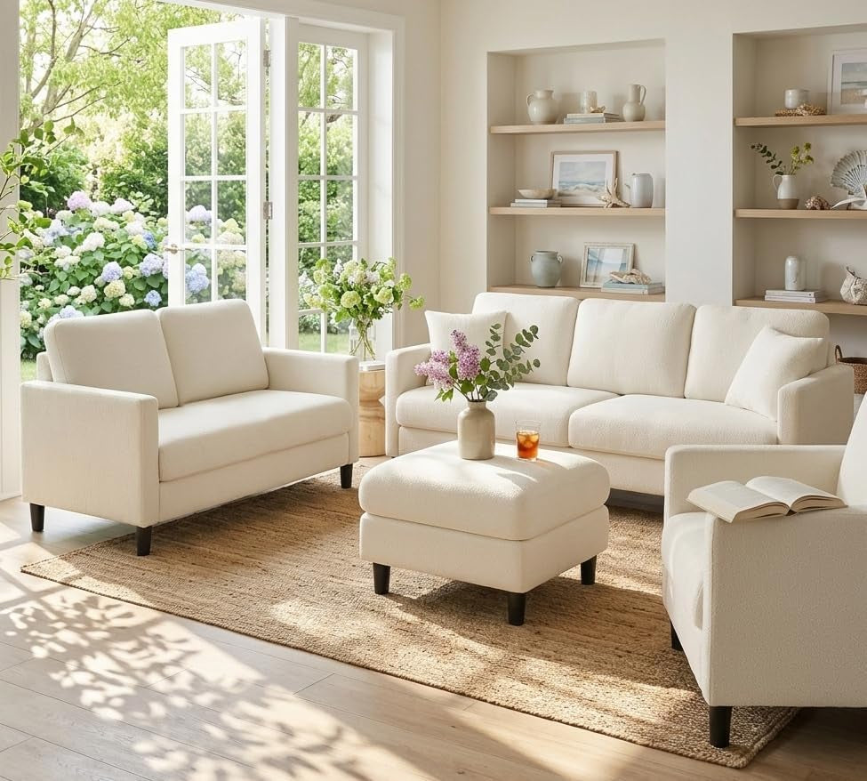 Bright living room staged with a beige sofa, matching loveseat, armchair and ottoman on a woven rug.