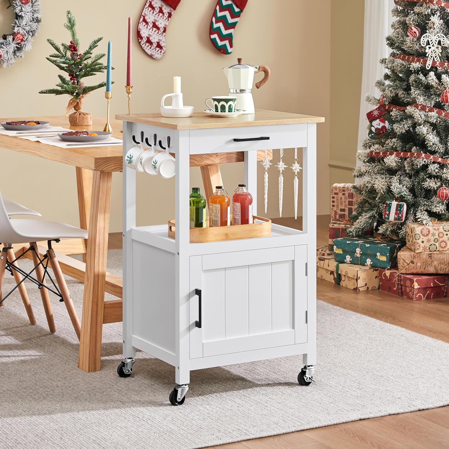 White rolling kitchen cart with wood-grain top shown in a decorated dining room beside a table and tree