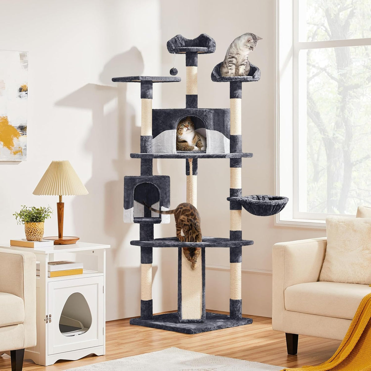 Dark gray cat tree next to sofa and window with cats using ramp and perches