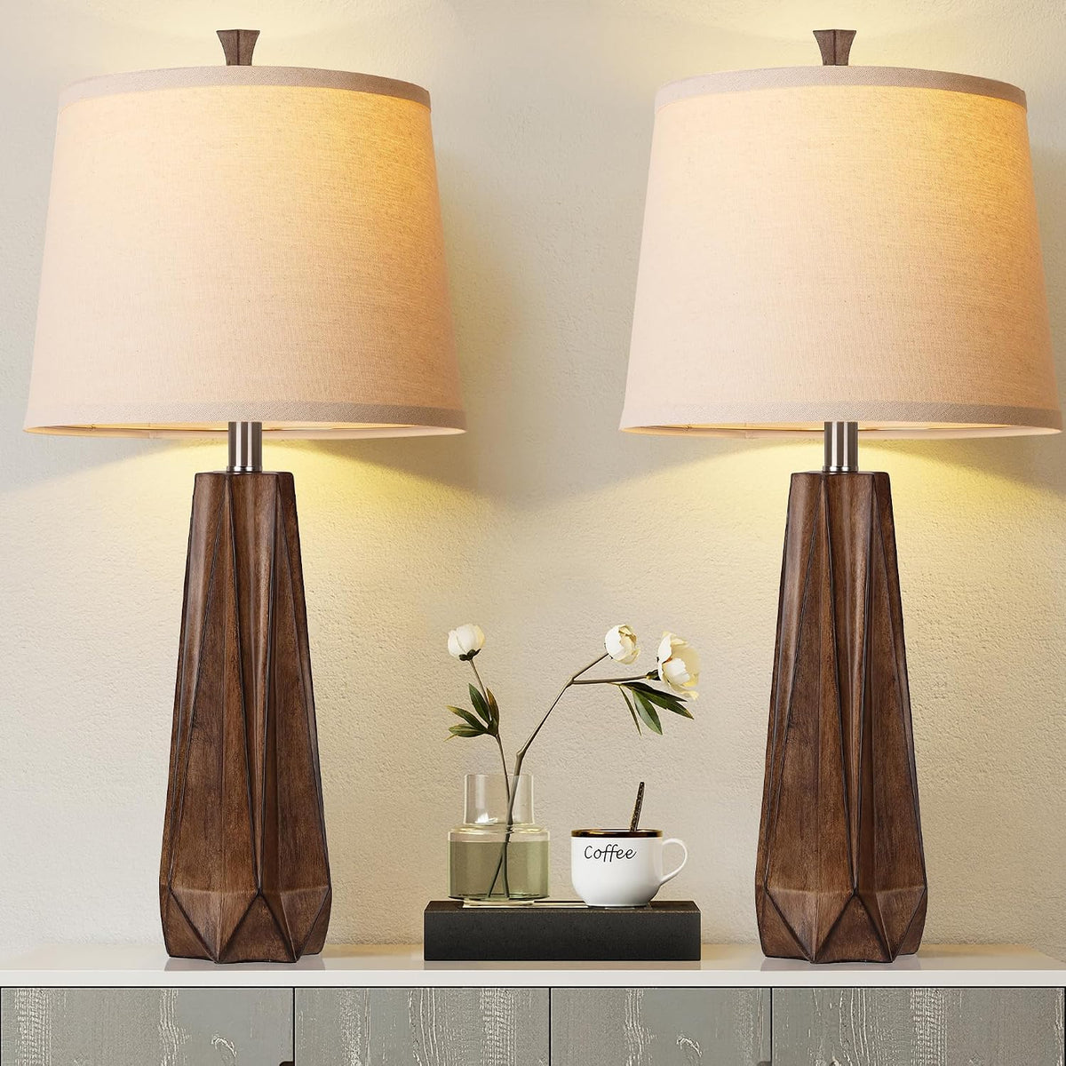 Two wood-grain resin table lamps with beige linen shades shown front view on a console