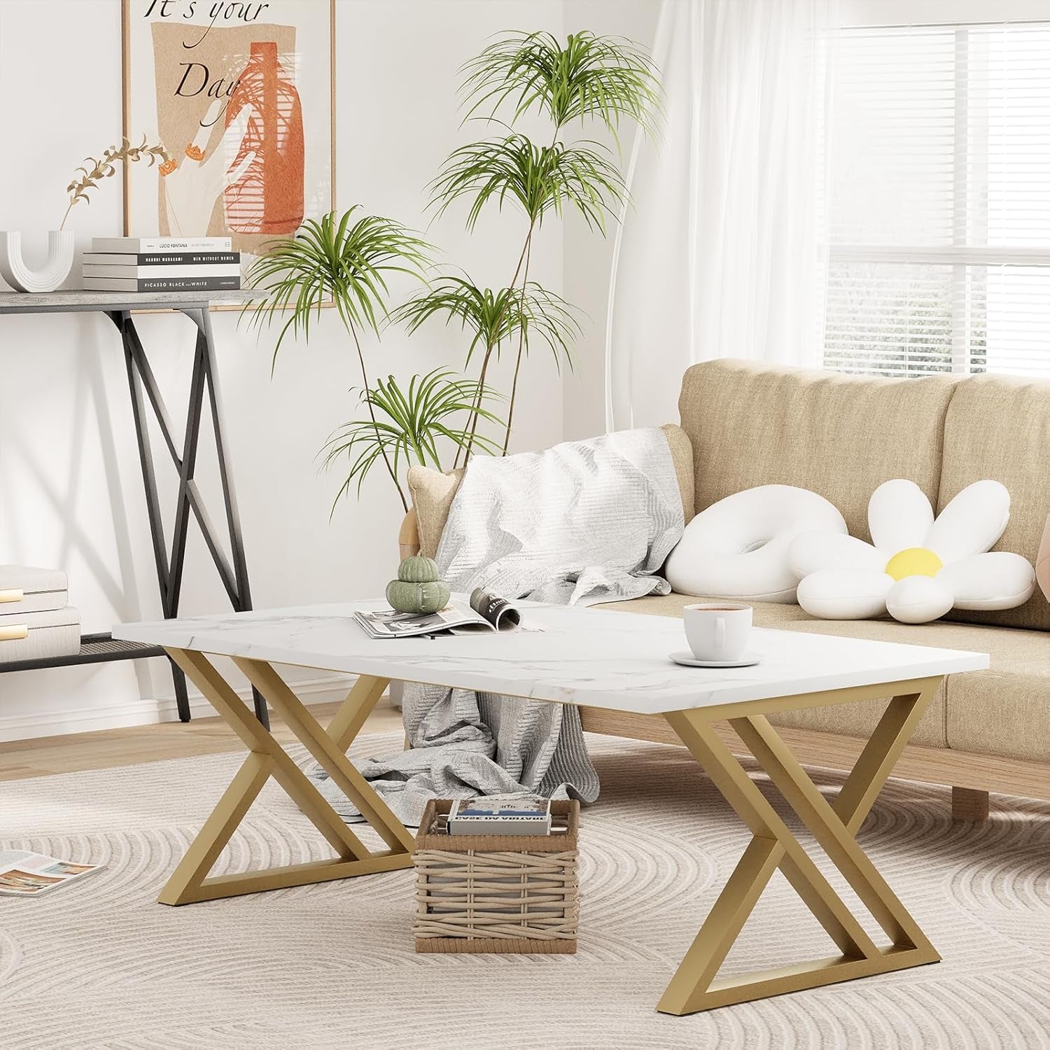 Rectangular faux marble coffee table with crossed gold X-legs centered on a sunlit living room rug