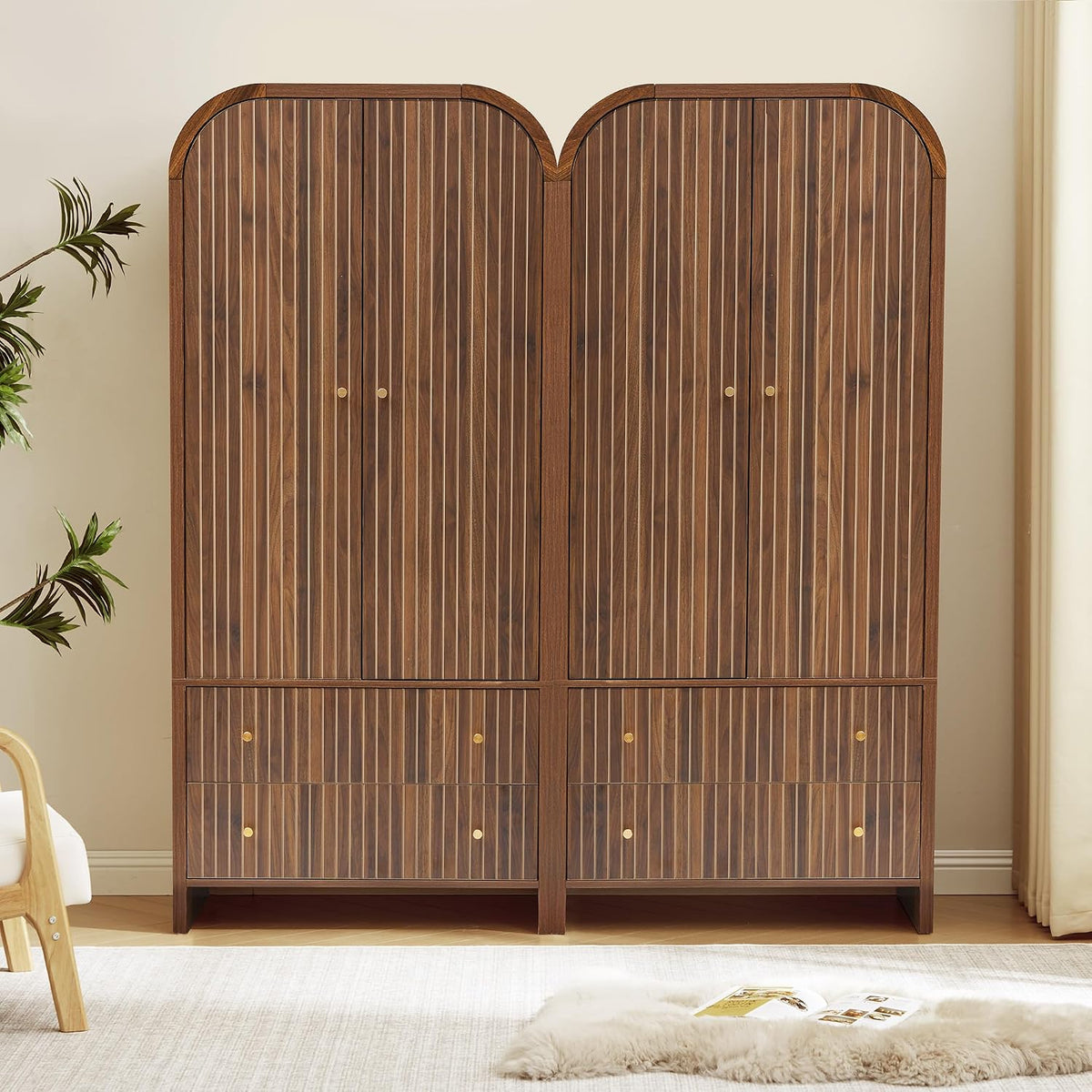 Two matching arched walnut wardrobes side by side showing symmetrical fluted fronts and drawers