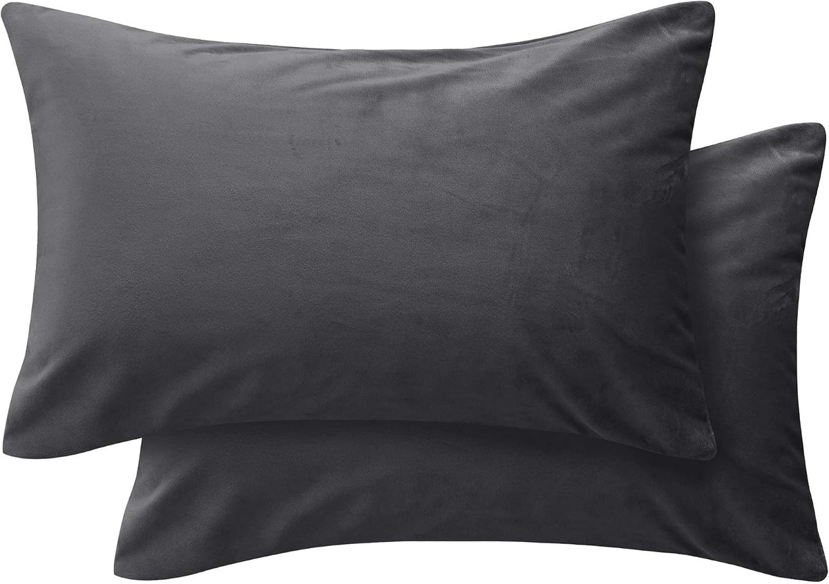 Two dark charcoal square pillow covers overlapped on a white background