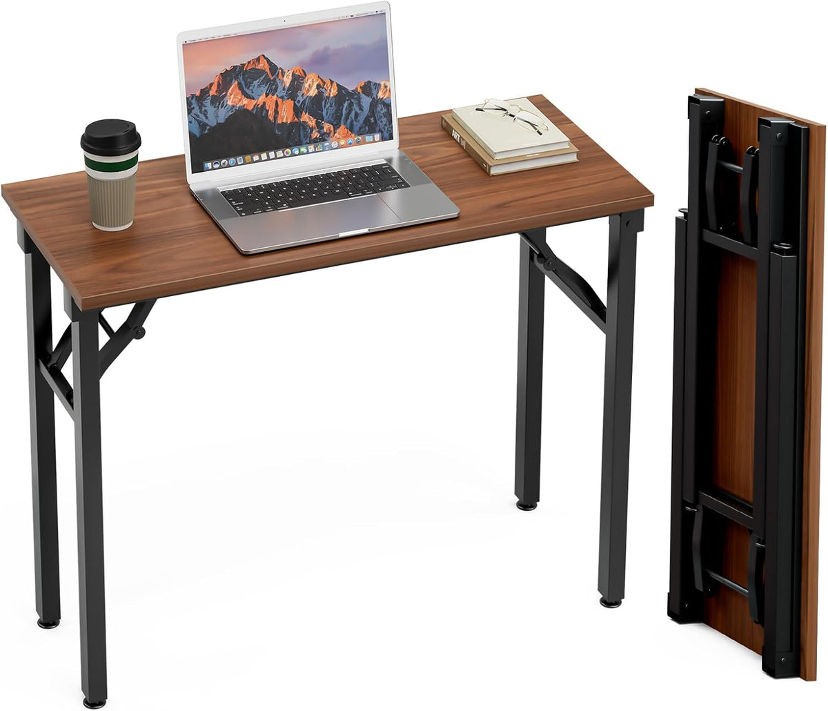 Brown wood desk from the side with laptop; a second folded tabletop with collapsed legs stands beside it.