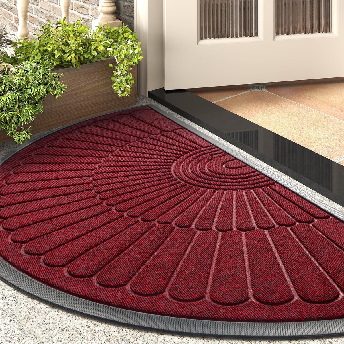 Deep red semicircular mat shown at a front door corner with planter and tiled threshold