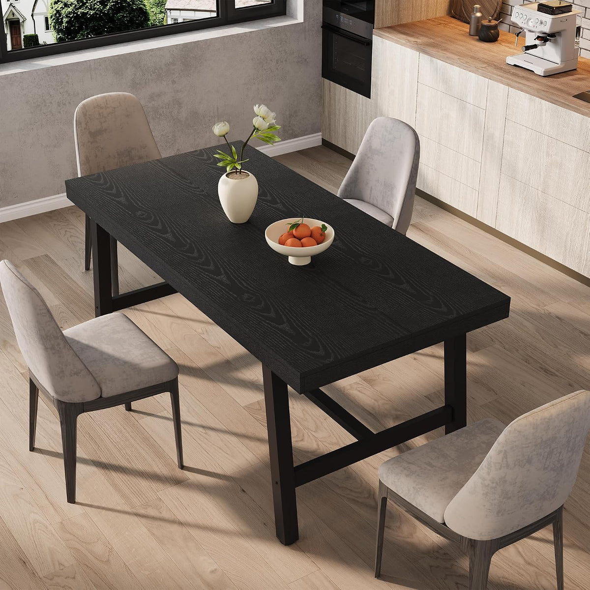 Angled view of the extended black tabletop with a vase and bowl, flanked by two light-upholstered chairs.