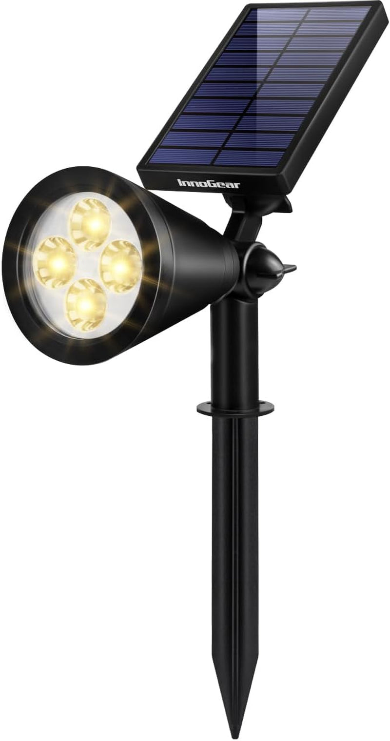 Single black solar spotlight close-up showing adjustable joint, panel and four warm LED bulbs.