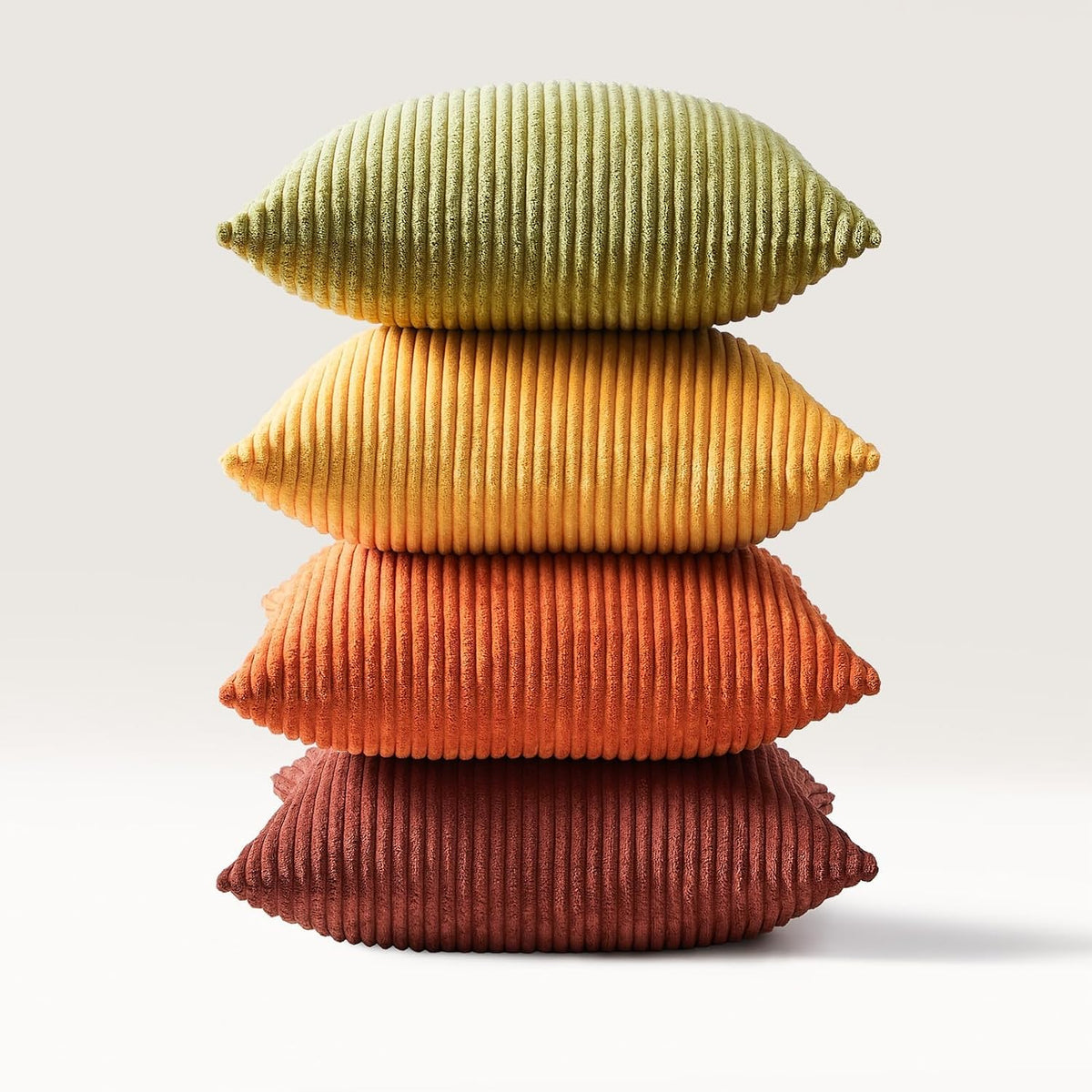 Four corduroy pillows stacked vertically to show colors and ribbed detail from green at top to deep red at bottom