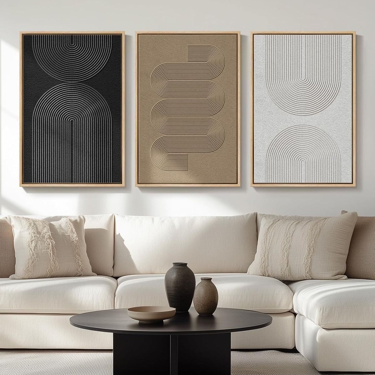 Three vertical framed panels with raised linear textures in black, tan and white above a beige sectional.