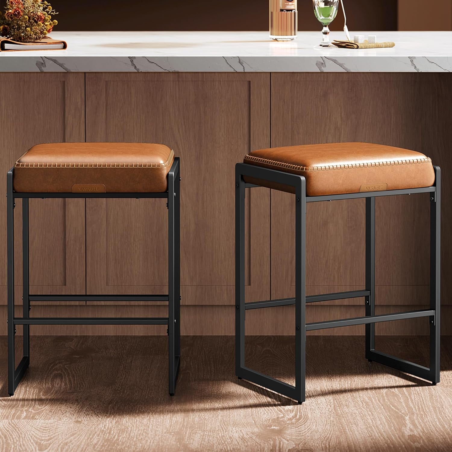 Caramel brown PU leather bar stools set of two with black metal frames, front view beside a kitchen counter