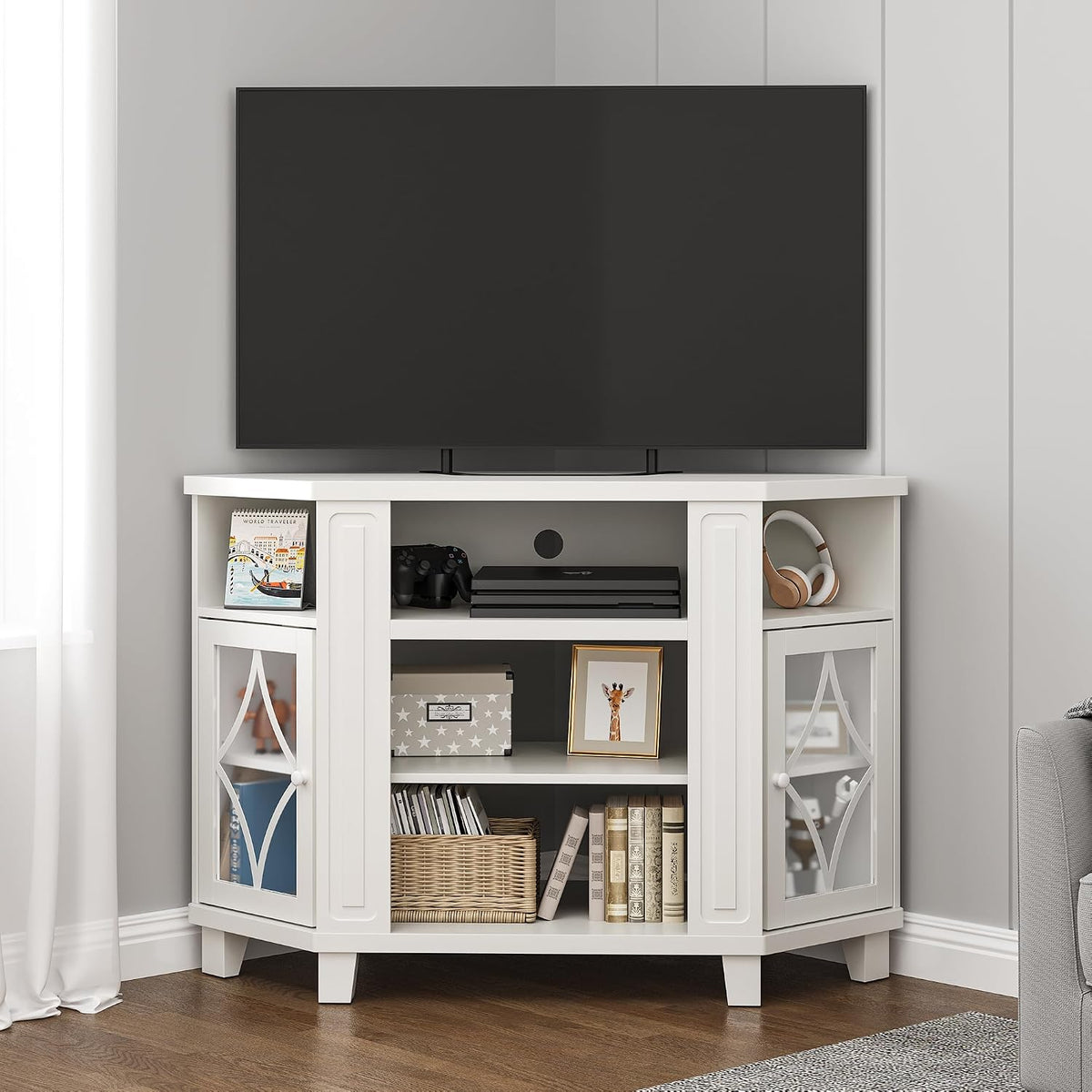 White corner media console with a TV on top and the central open shelf holding a game console and accessories