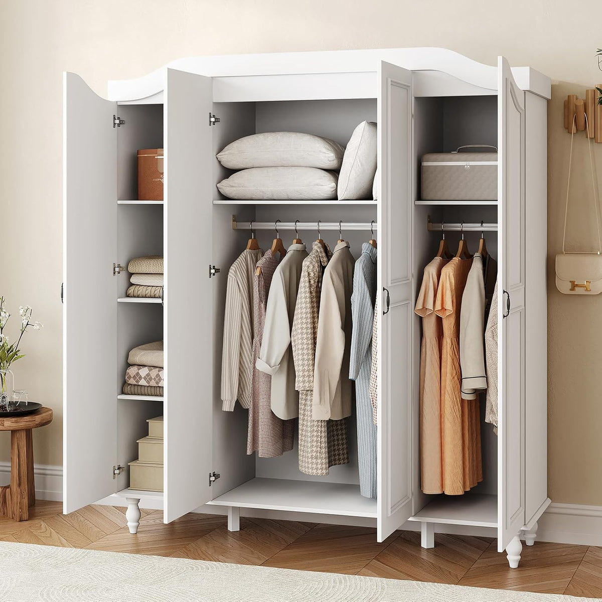 Armoire with all four doors open showing shelves, two hanging rods and clothes hung on wooden hangers.