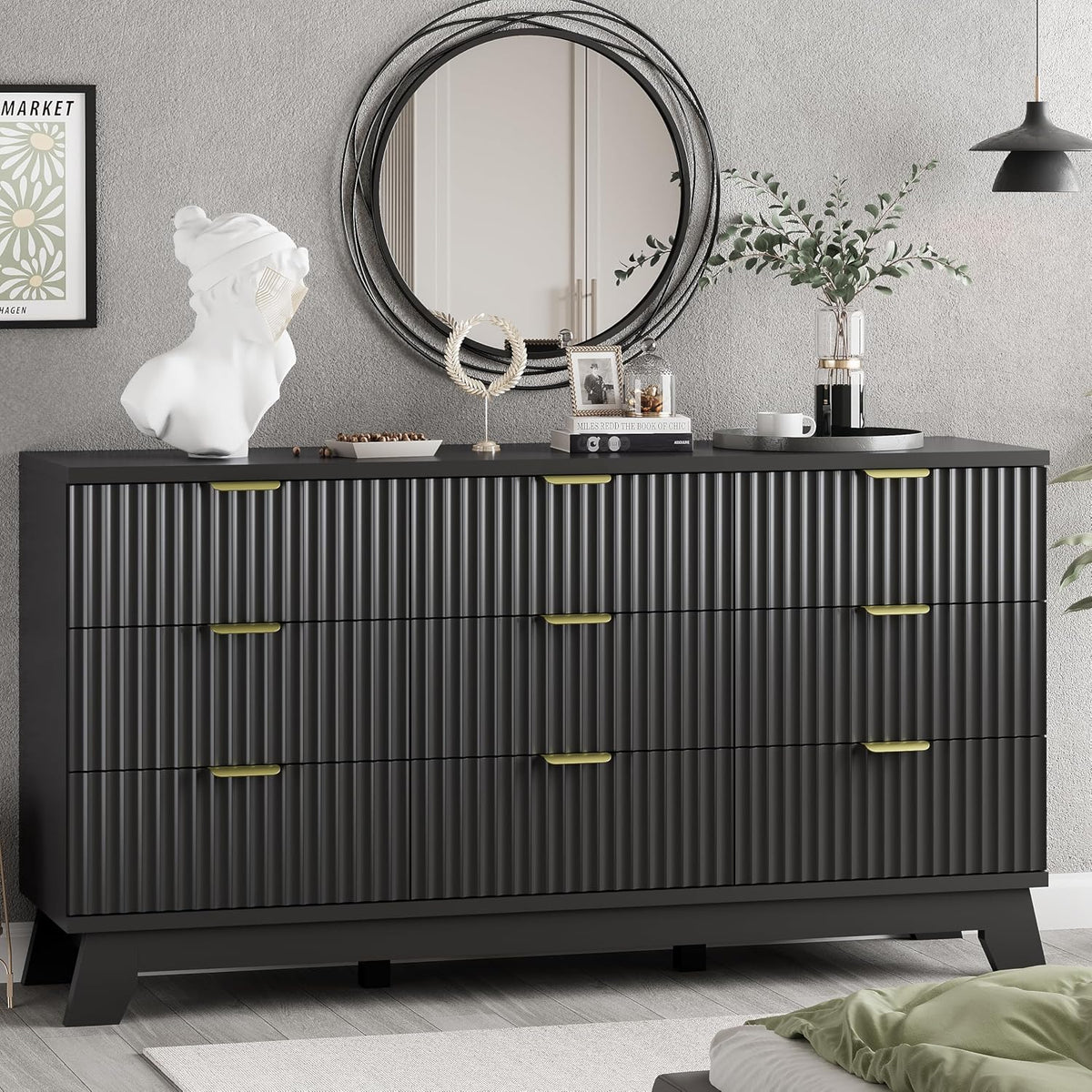 Black dresser with ribbed vertical drawer fronts, gold-tone handles and decorative items on top.