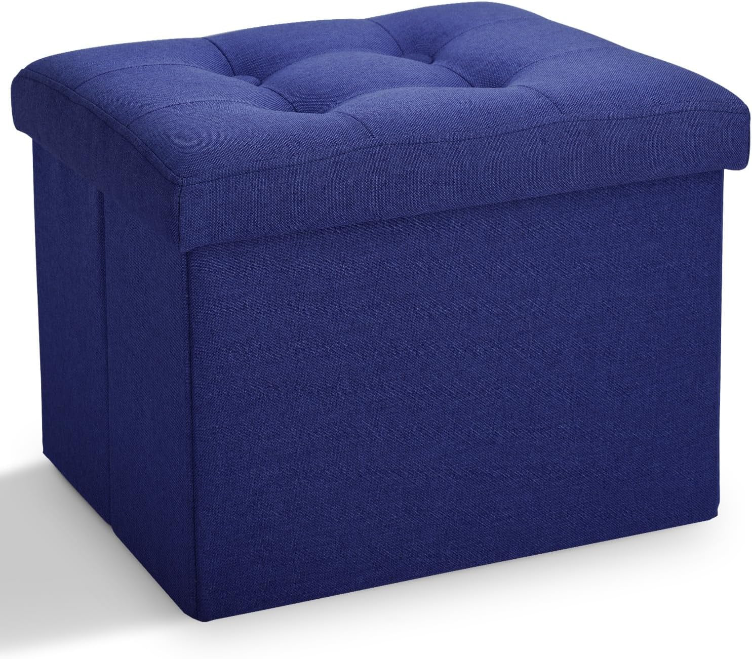 Three-quarter view of a square deep blue fabric storage ottoman with tufted cushioned top.