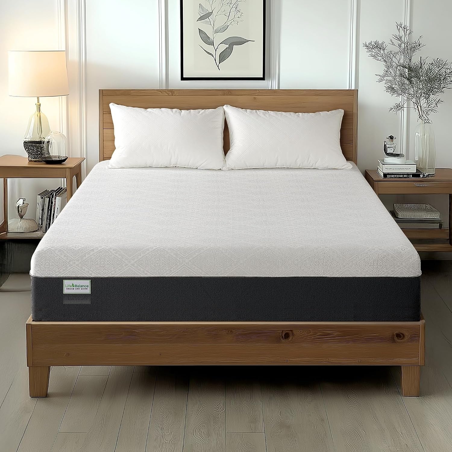 White-and-dark-gray mattress on a wooden bed in a bright bedroom with two pillows and side tables.