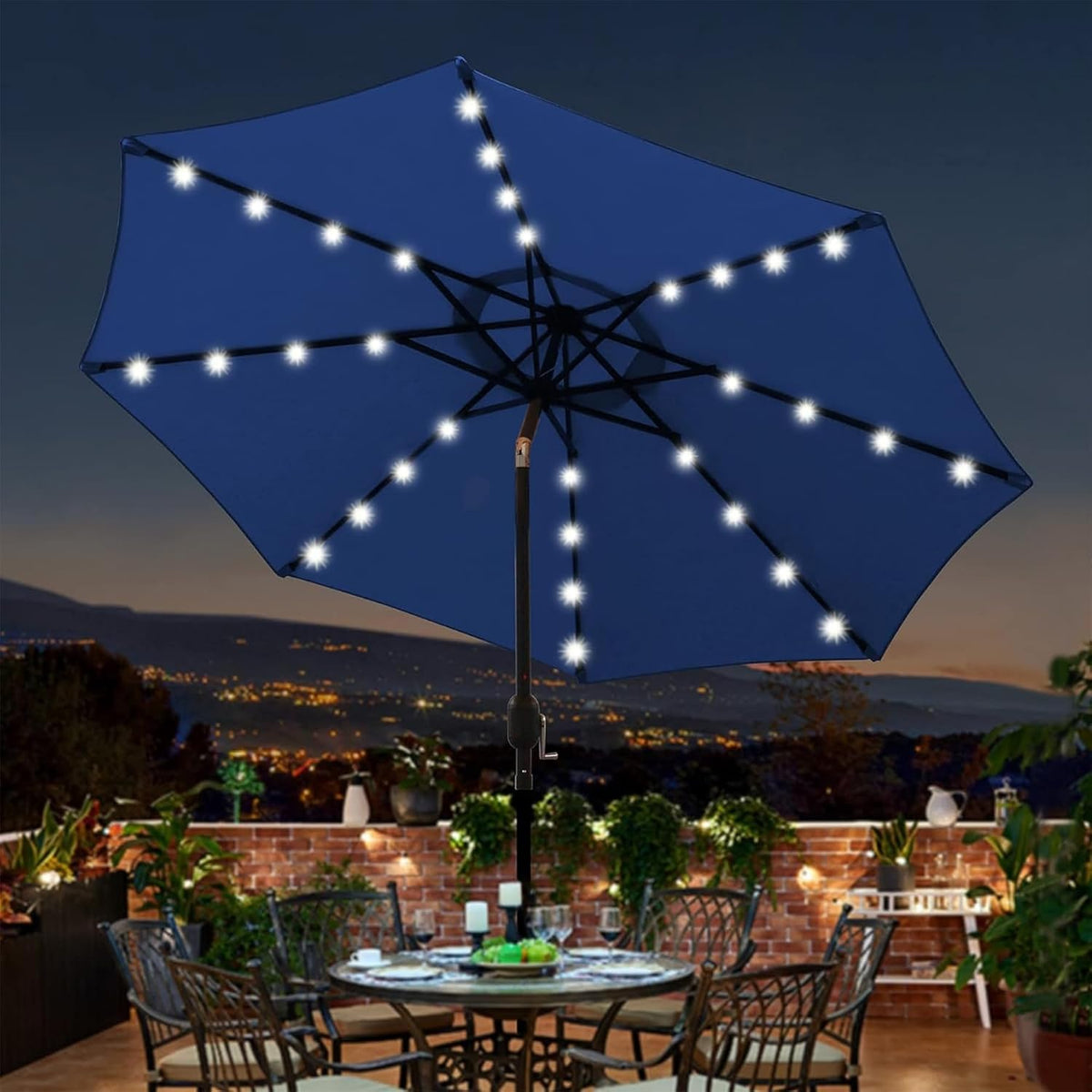 Evening terrace with a blue umbrella showing LED lights along each rib above a set dining table and brick wall.