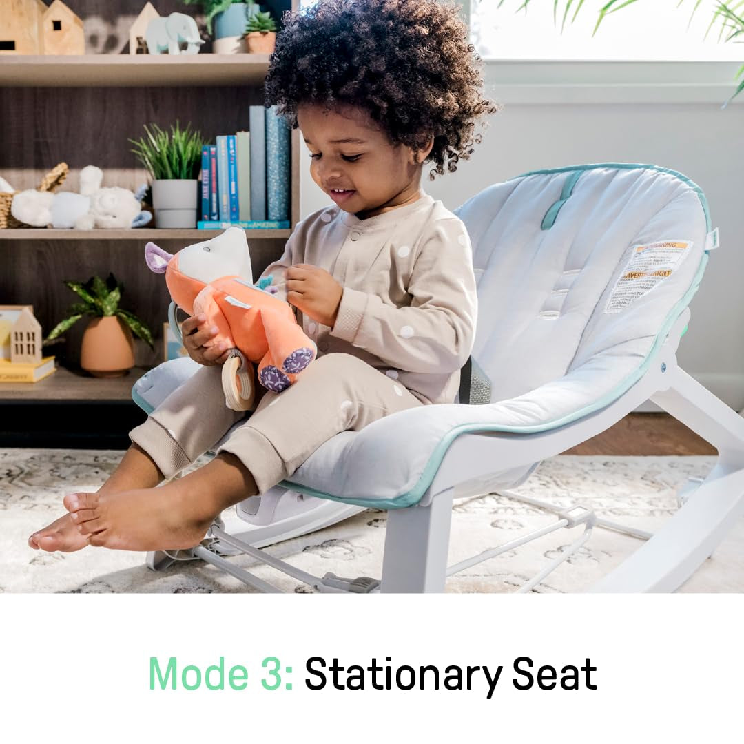 Toddler seated in the stationary seat playing with a stuffed toy in front of a bookshelf