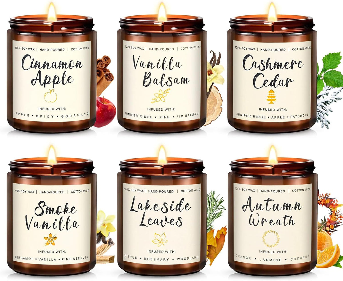 Front view of six amber glass jar candles in two rows, each lit with a small flame and scent icons behind them