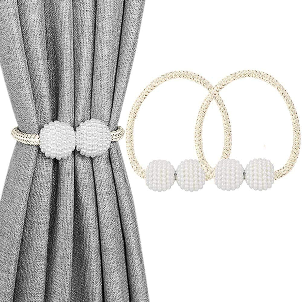 Gray curtain pulled with a cream-colored braided tieback showing two small white beaded balls.