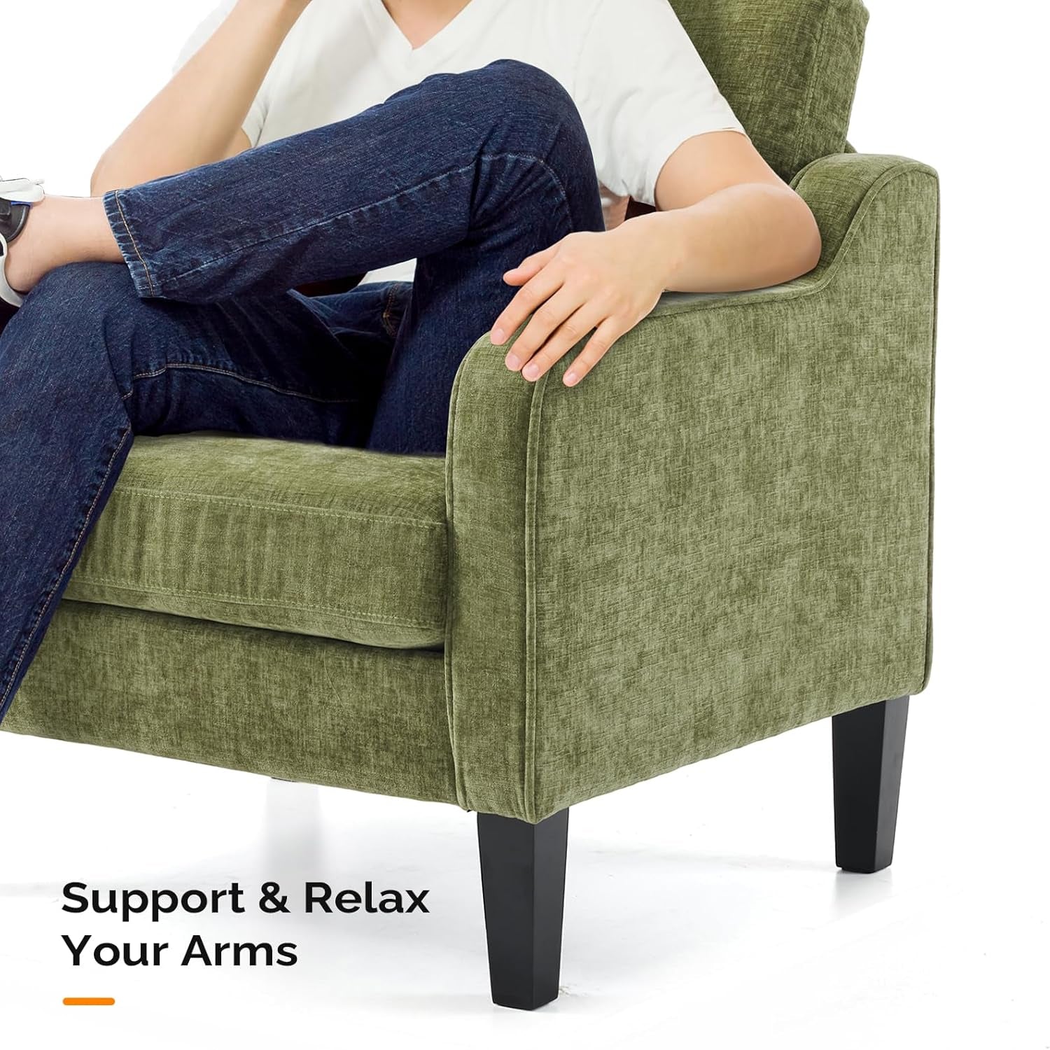 Close-up of a green upholstered chair arm and black tapered wooden leg with a person seated.
