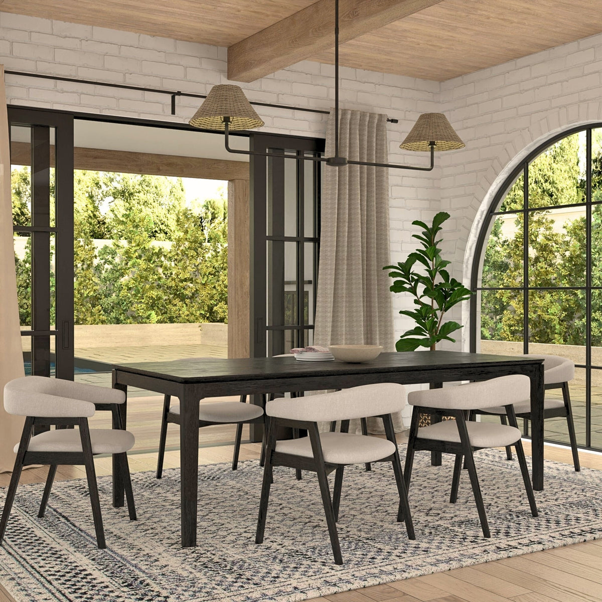 Black rectangular dining table surrounded by light upholstered chairs in a bright dining room.